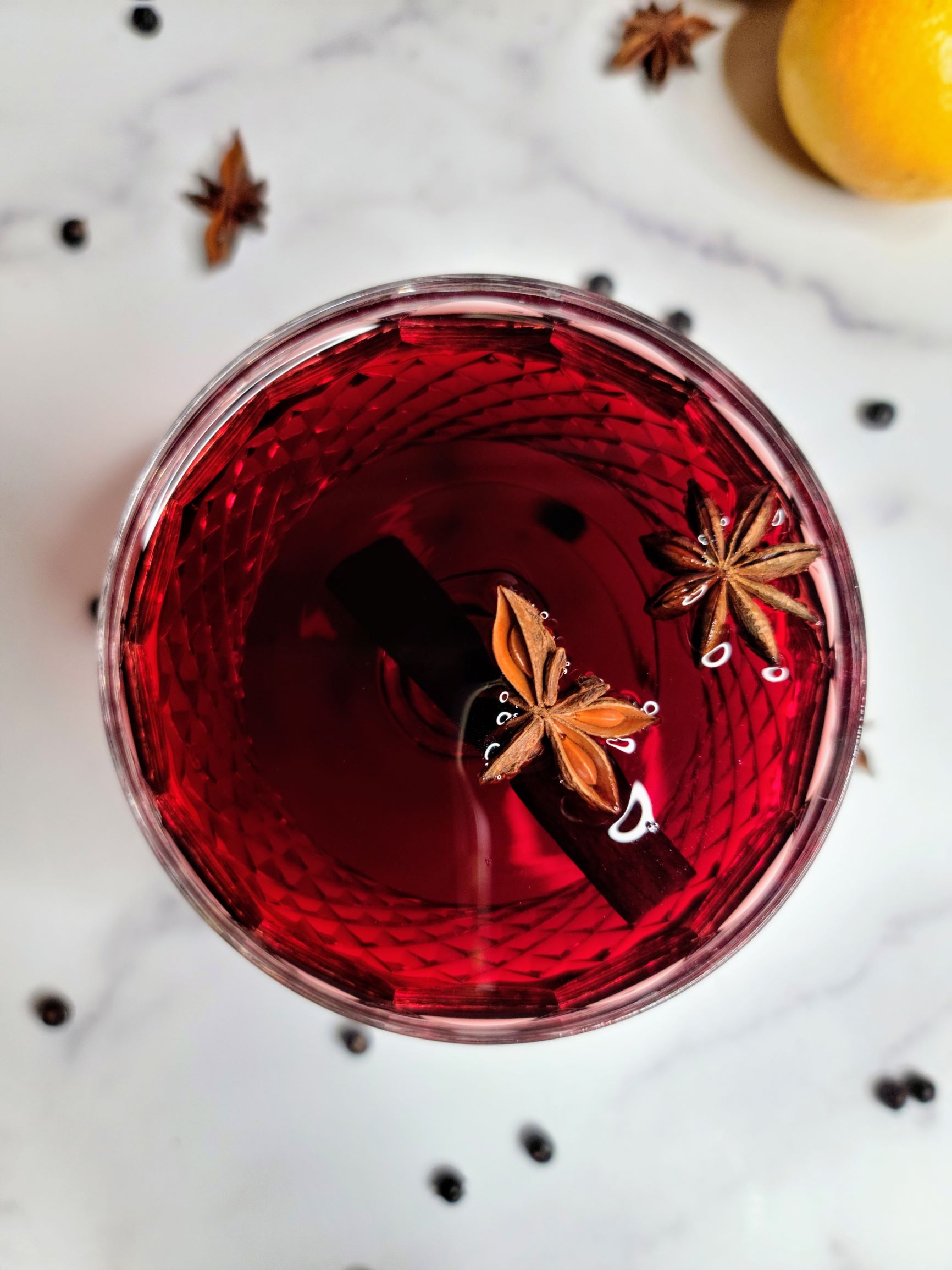 Spiced mulled wine in glass, with cinnamon sticks and star anise.