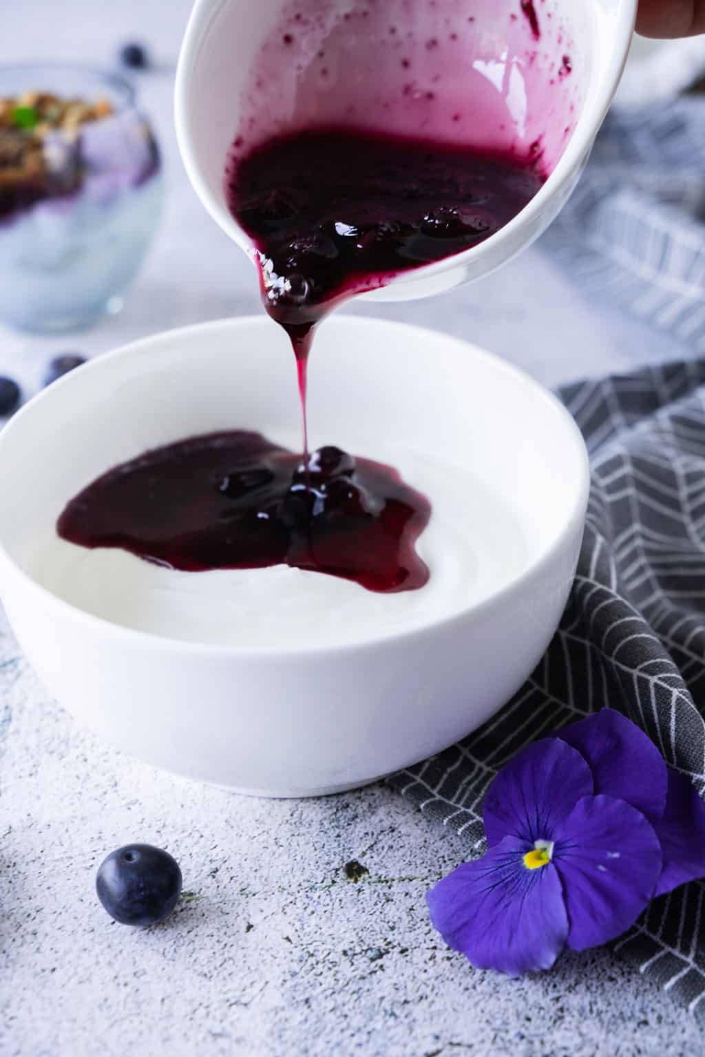 Blueberry compote poured over yogurt.