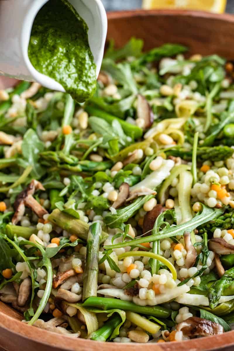 dressing poured on couscous salad in bowl