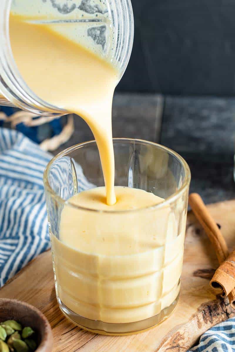 pouring passionfruit lassi in a glass