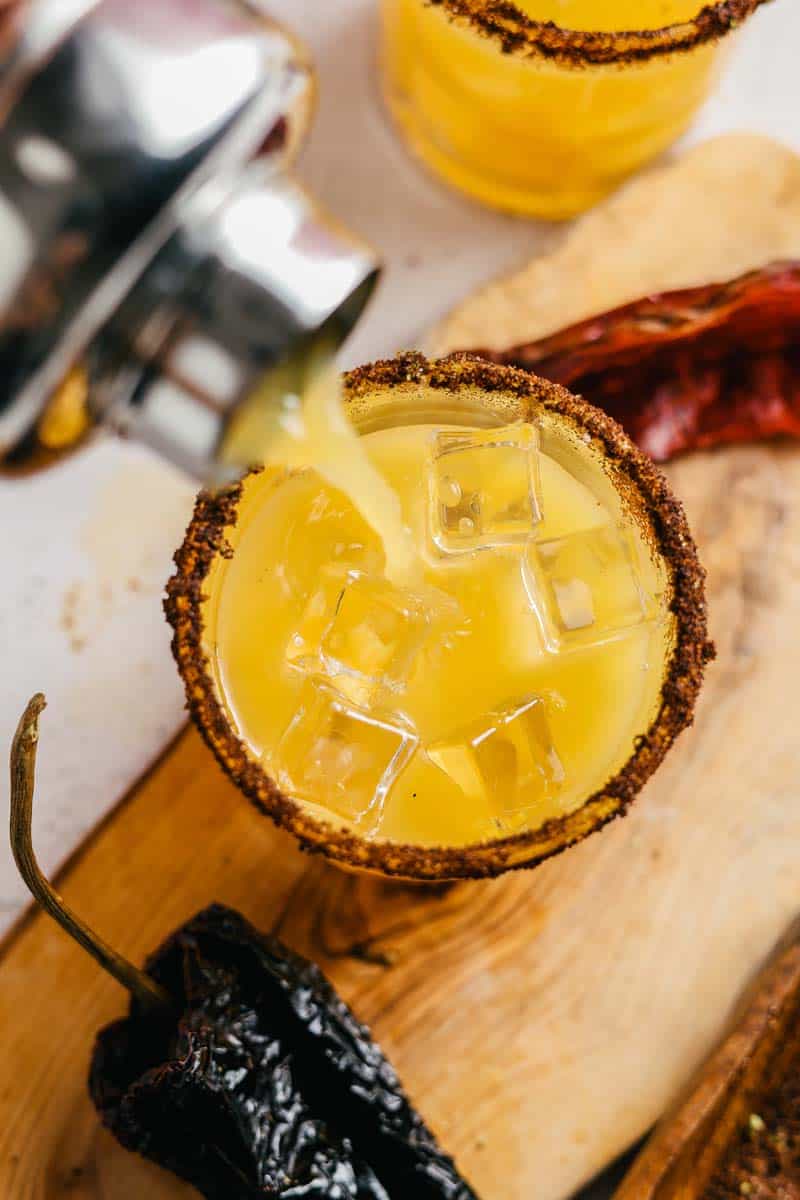 pouring classic margarita into a cocktail glass