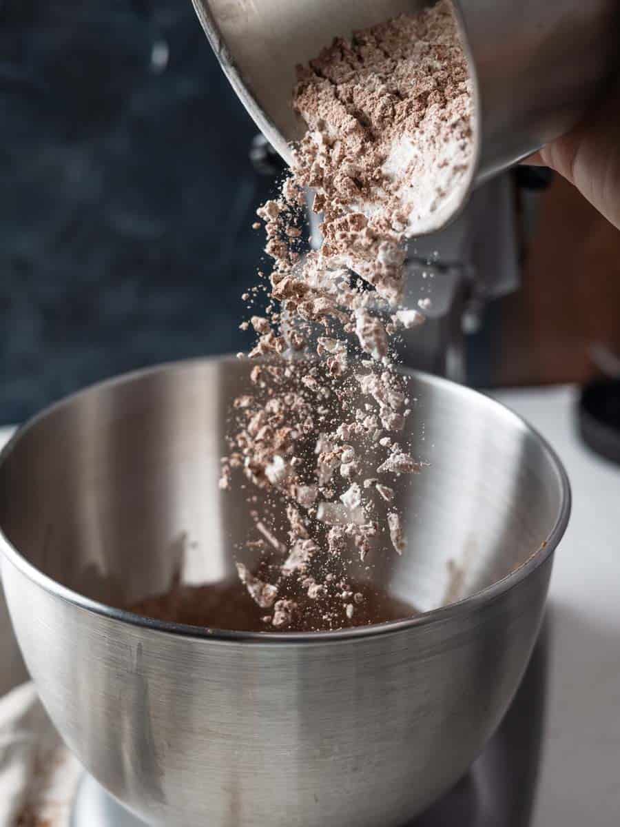 pouring dry ingredients into wet ingredients to make chocolate cookies